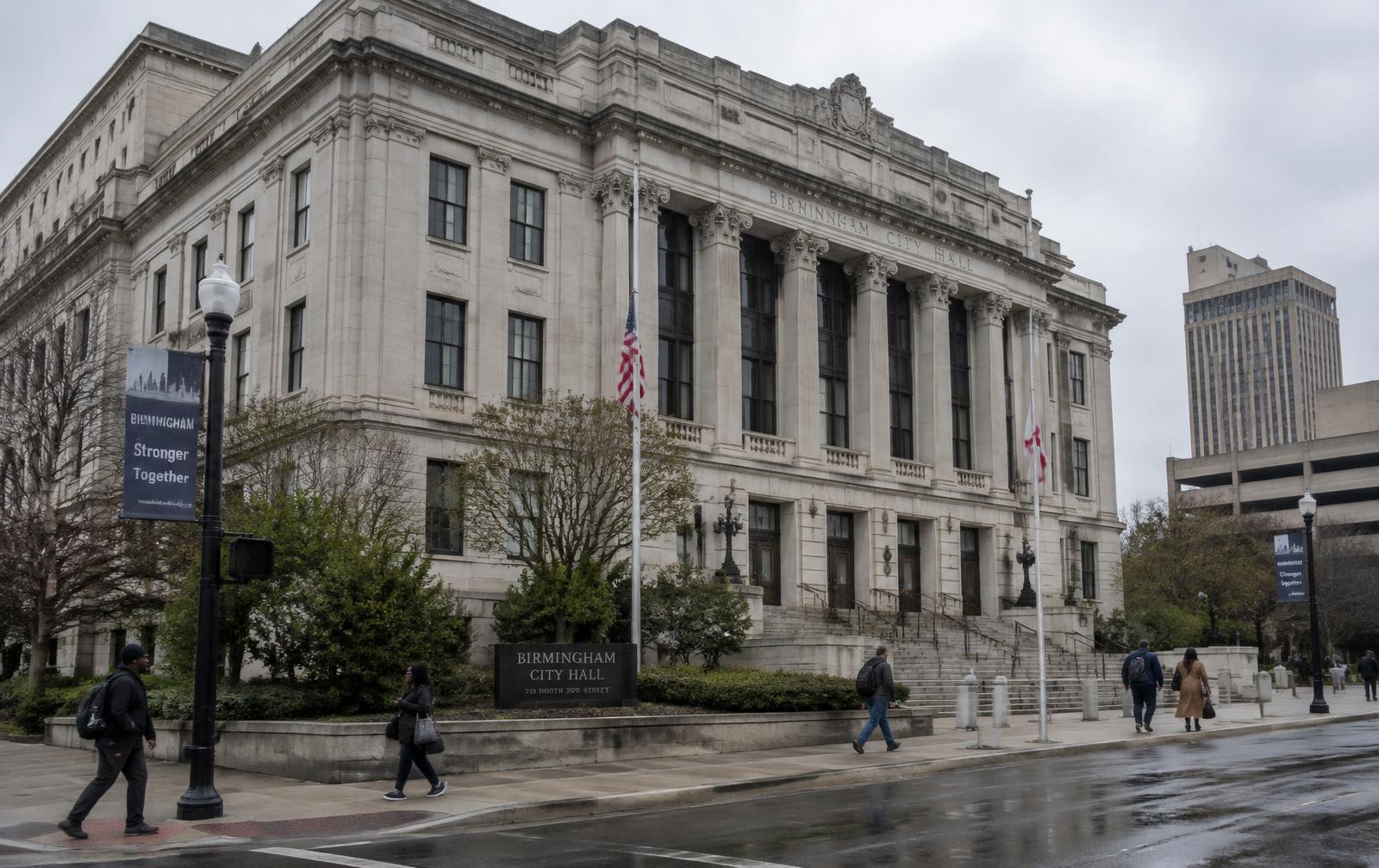 Birmingham City Hall on an overcast morning as people pass on the sidewalk